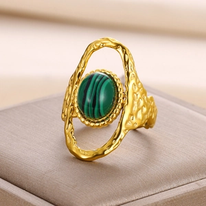Détail d'une bague soleil dorée sertie de turquoise sur un support en velours