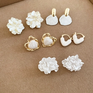 Detailed view of elegant gold and cream floral heart pearl stud earring set