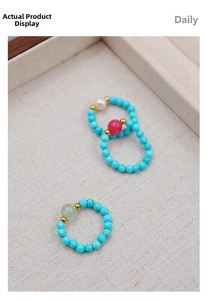 Detail view of handmade turquoise stretch rings with freshwater pearls and gold beads