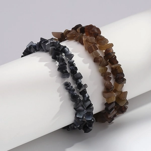Close-up of irregular black and brown cat eye stone bead bracelets on white display