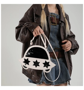 Détail d'un sac ovni avec découpes en étoile et bandoulière réglable porté par un mannequin