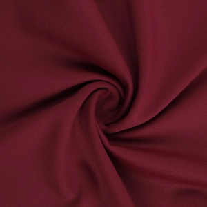 Macro shot of wine red knitted fabric showing soft drape and fine textile texture