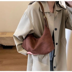 Close-up of brown suede shoulder bag featuring a minimalist vintage matte texture