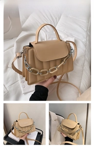 Detail view of khaki crossbody bag with vertical stitching and chunky chain decor