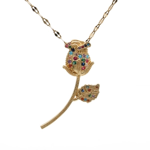 Elegant gold rose necklace pendant with colorful gemstone accents on white background