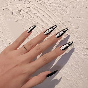 Halloween long stiletto press-on nails with black base and white bone skeleton patterns