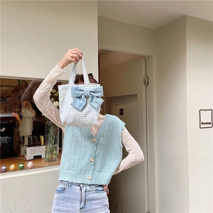 Detail of light blue gingham tote bag with large decorative bow on front side