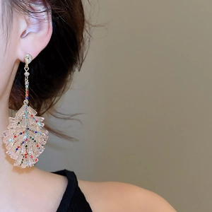 Detailed view of leaf-shaped bohemian earrings featuring layered crystals and colorful rhinestones