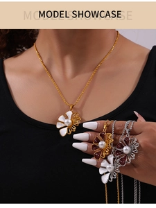 Dettaglio della collana con ciondolo a fiore in smalto con perla e catena a tortiglione