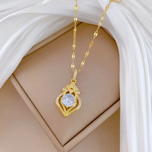 Elegant gold-tone teardrop pendant necklace with sparkling crystal inlay on silk background