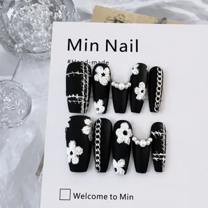 Handmade press-on nails set with black matte finish, 3D floral accents, and pearls