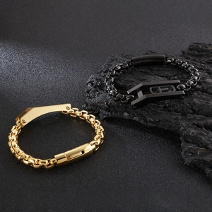 Detailed view of gold and black hip-hop chain bracelets on a dark rock background