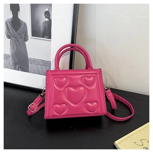 Détail du sac à main rose en similicuir avec motifs cœurs et bandoulière réglable