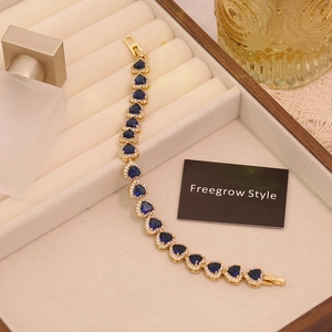 Detailed shot of 18K gold plated heart bracelet with sapphire blue stones and crystals