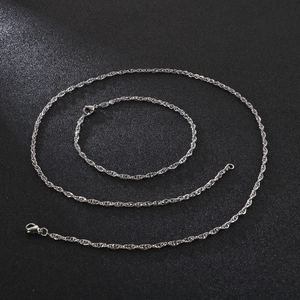 Detailed close-up of shiny silver titanium steel link chains on a black textured surface