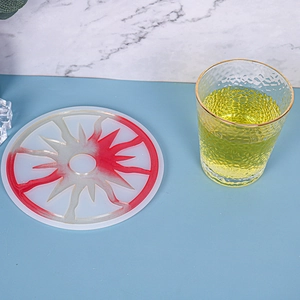 Detail of red and white resin sun coaster with glitter texture and radial sunburst design