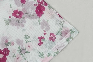 Close-up of translucent pink floral mesh fabric texture with elegant flower pattern