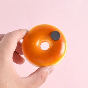 Realistischer PU Donut Kühlschrankmagnet mit hoher Rückprallkraft auf rosa Hintergrund