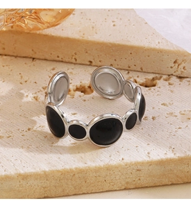 Macro detail of adjustable stainless steel ring with black enamel oval link design