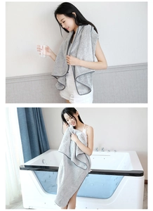 Detail view of wearable gray striped coral fleece bath towel with soft textured edging