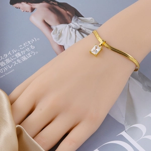 Detalle de pulsera de cadena de serpiente dorada con circonita cuadrada sobre seda
