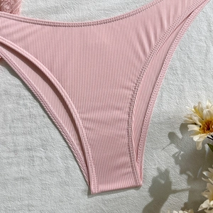 Detailed close-up of pink ribbed swimwear fabric and high-quality double stitching