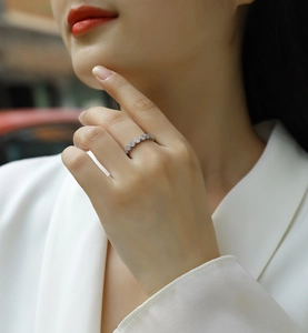 Close-up of elegant S925 sterling silver eternity ring with round cut moissanite on finger