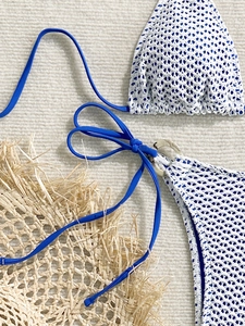 Detailed macro of crochet knit bikini with blue lining and decorative tortoiseshell ring