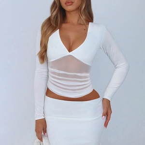 Détail d'un ensemble blanc deux pièces avec patchwork en mesh et décolleté en V profond