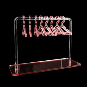 Pink acrylic jewelry organizer with 7 mini hangers for earrings on a sleek black background