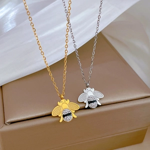 Détail de colliers abeille or et argent avec cristaux incrustés sur un coffret cadeau