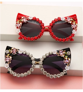 Close-up of cat-eye sunglasses with rhinestone edges, floral and bee metal accents