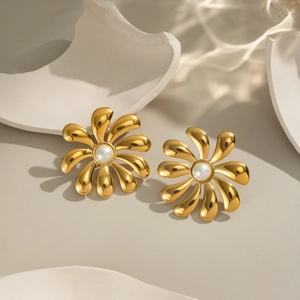 Luxury 18K gold-plated flower stud earrings with elegant white pearls on stone backdrop