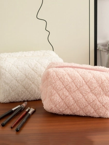 Cute quilted fleece pencil cases in pink and white colors on a wooden desktop
