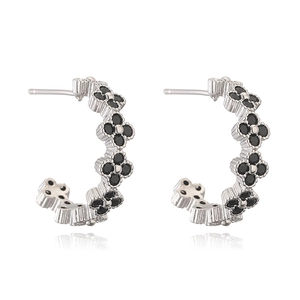 Detailed view of silver clover earrings featuring inlaid black stones with reflection