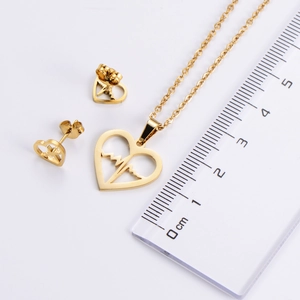 Détail de l'ensemble bijoux cœur doré avec une règle pour mesurer la taille du pendentif