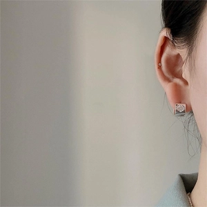 Close-up of a sterling silver heart-shaped zircon ear cuff on a model's earlobe