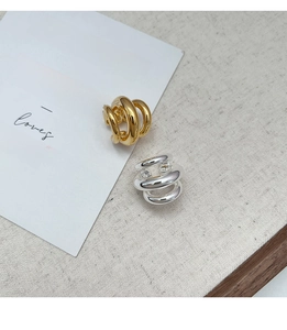 Close-up of geometric multi-layer ear cuffs in polished gold and silver finishes