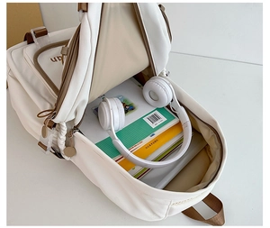 Interior view of the white nylon school backpack showing spacious storage and headset
