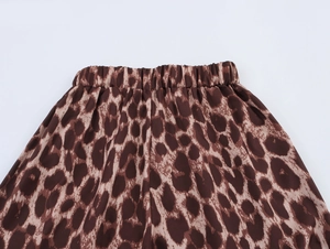 Close-up of the elastic waistband and classic leopard print on brown loose trousers