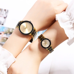 Matching couple watches with gold dials and black steel bands worn on wrist