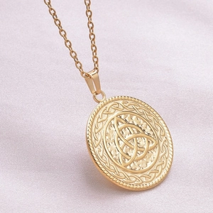 Macro shot of 18k gold plated stainless steel Celtic knot round necklace pendant