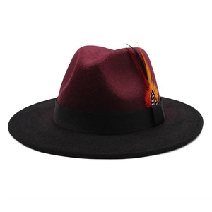 Detail of burgundy wool fedora featuring a gradient feather and black ribbon band