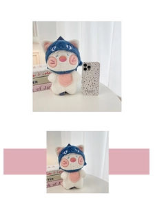 Detail shot of cute pink plush doll wearing a blue shark hat with soft texture