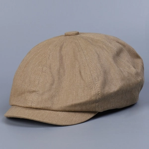 Detail view of khaki newsboy cap showing twill cotton texture and top button finish