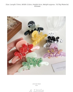 Detailed close-up of colorful butterfly acetate hair clips with inlaid rhinestones