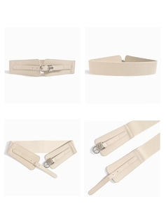 Detail of beige wide elastic waist belt featuring silver metal double ring buckle