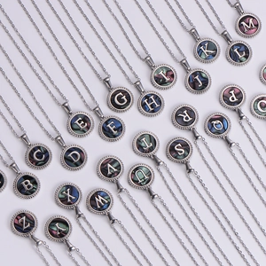 Macro view of silver round pendants with iridescent shell inlay and A-Z letters detail