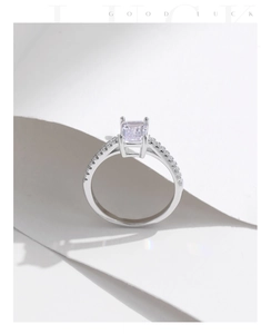 Macro detail of silver ring with emerald-cut pink stone and sparkling pavé diamonds