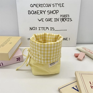 Detailed view of yellow plaid drawstring stationery pouch with Sozanni woven label